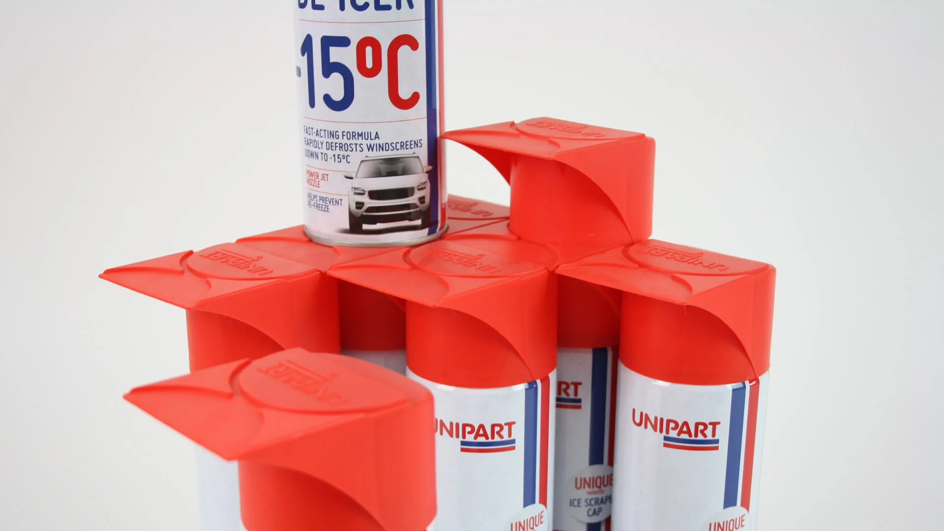 An array of capped de-icer cans nested together with one can standing on the caps below it, showing that the design stacks vertically as well as side by side.